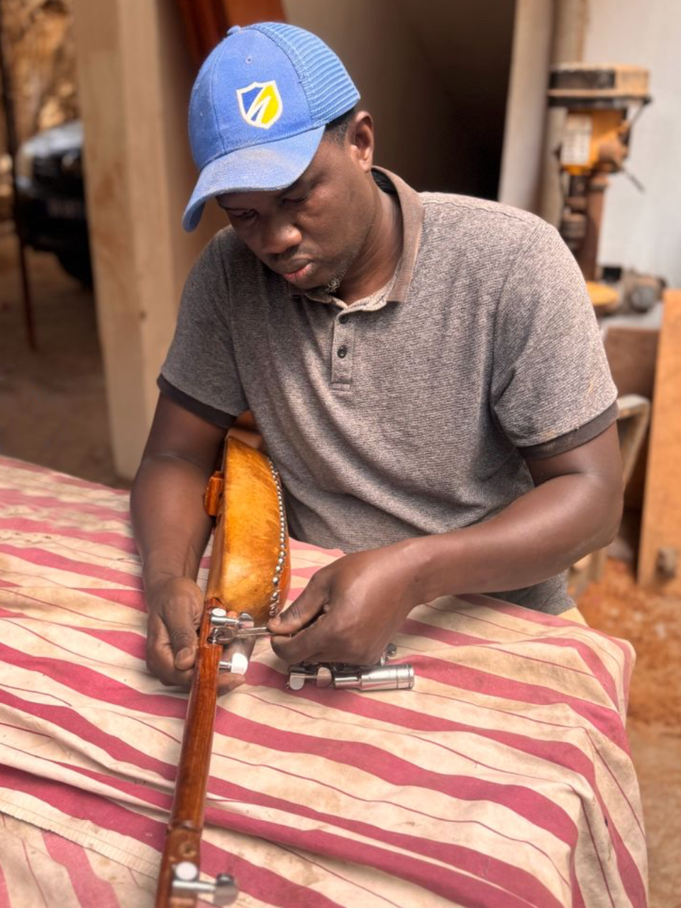 Abdoulaye Traoré Diop installing tuning machines on a xalam